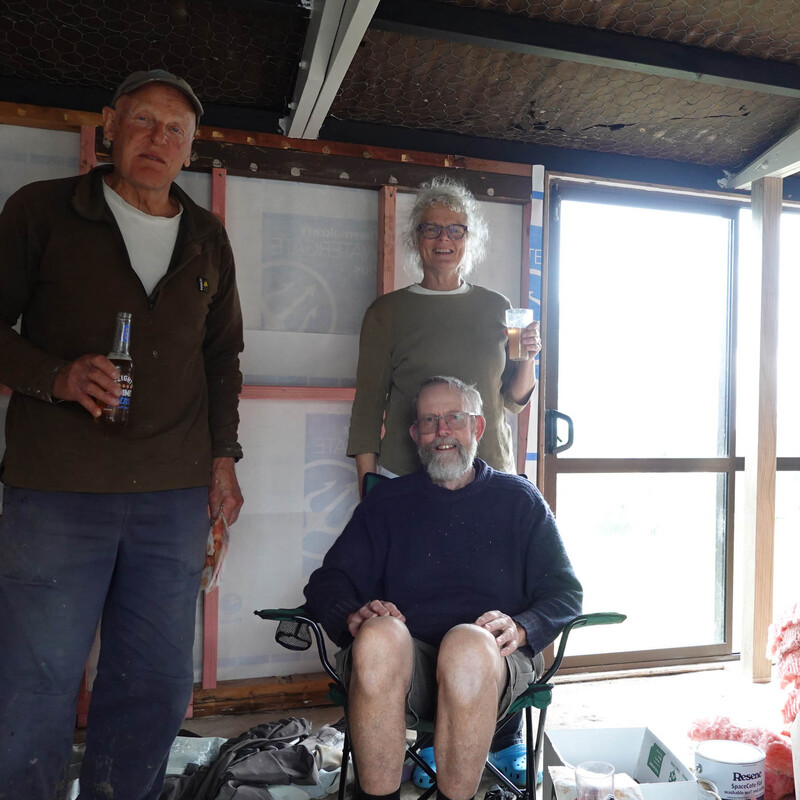 The Build Team - that's us - Stewart and Ngaire - standing and Mark the builder having a well-earned rest