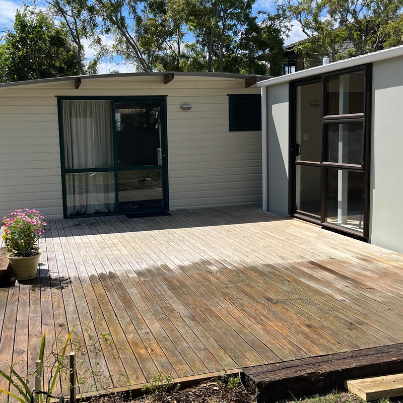 Cabin to the left, Living Shed to the right.  In the middle of a deck scrub