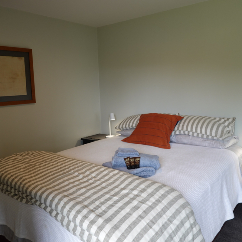 Queen size bed with feather pillows and linen duvet